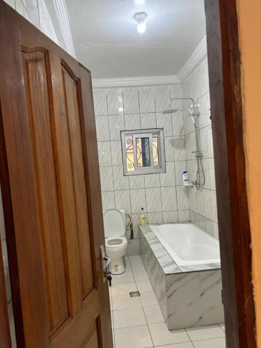 a bathroom with a tub and a toilet and a sink at Eden Meadows Estate (Dr. John) in Limbe