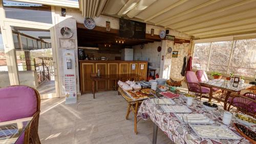 une pièce avec des tables et des chaises et une cuisine dans l'établissement Hikmet's House, à Avanos