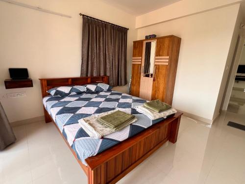 a bedroom with a bed with two towels on it at Nirvana Stay, Spacious Fully furnished 2bhk apartment in Mangalore, Full AC in Mangalore