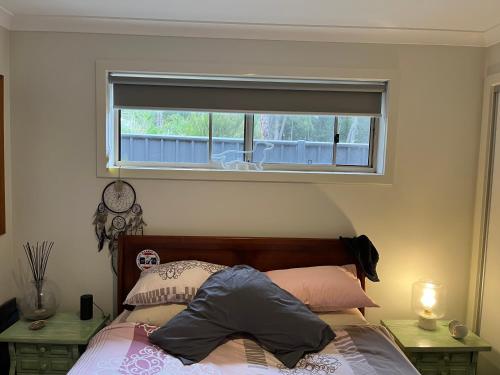 sypialnia z łóżkiem z oknem i łóżkiem sidx sidx sidx w obiekcie Country charm coastal living w mieście Tura Beach