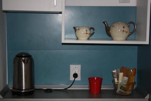 a counter top with two tea cups on a shelf at Retro Hostel in Cluj-Napoca