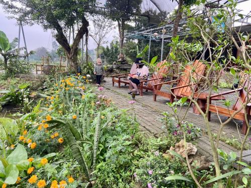 a group of people sitting on benches in a garden at Tam Coc Mountain View Homestay in Ninh Binh