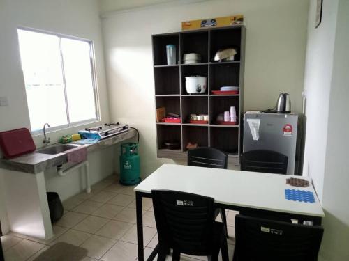 uma cozinha com uma mesa, um lavatório e um frigorífico em SKE Longhouse Homestay #2 em Sipitang
