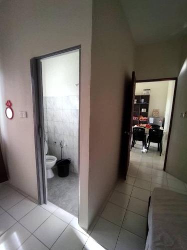 um quarto com casa de banho com WC e espelho em SKE Longhouse Homestay #2 em Sipitang