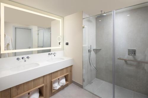 a bathroom with a sink and a shower at Courtyard by Marriott Cluj - Napoca Downtown in Cluj-Napoca
