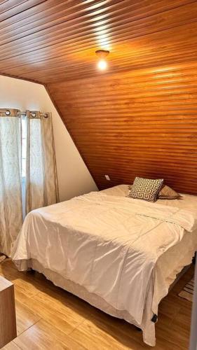1 dormitorio con 1 cama con techo de madera en Casa, en Siguatepeque