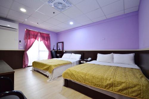 2 Betten in einem Zimmer mit lila Wänden in der Unterkunft 知本溫泉-彩溱旅宿 in Wenquan