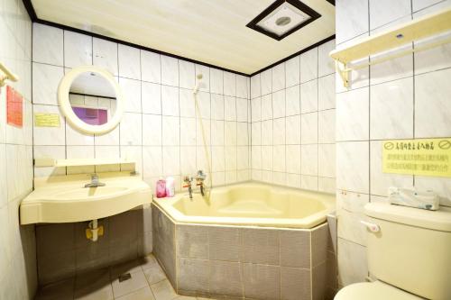 ein Badezimmer mit einem Waschbecken, einer Badewanne und einem WC in der Unterkunft 知本溫泉-彩溱旅宿 in Wenquan