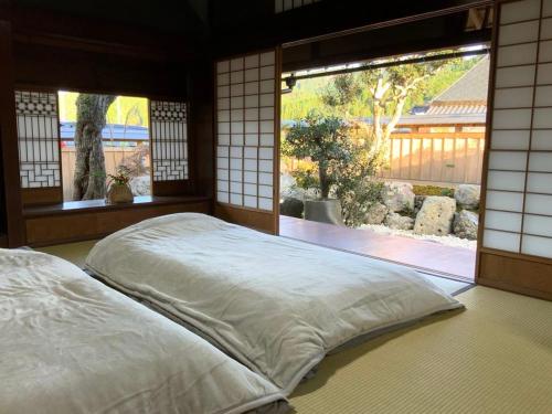 a bed in a room with a large window at tehen in Kyoto