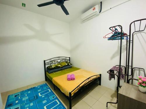 a room with two bunk beds and a ceiling fan at Homestay Teratak Tamu Tawau in Tawau