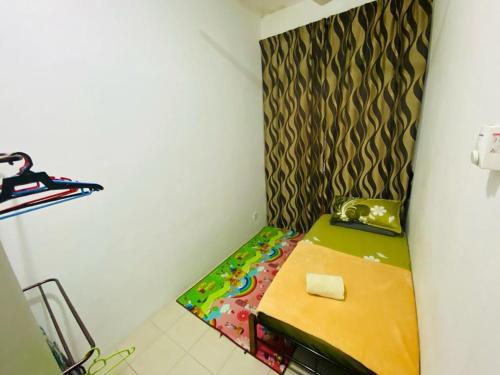 um pequeno quarto com uma cama no canto em Homestay Teratak Tamu Tawau em Tawau