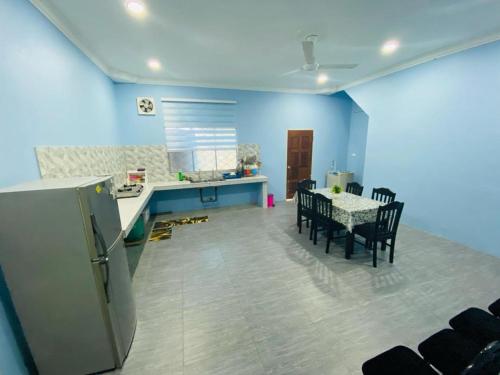 a kitchen and dining room with a table and chairs at Homestay Teratak Tamu Tawau in Tawau