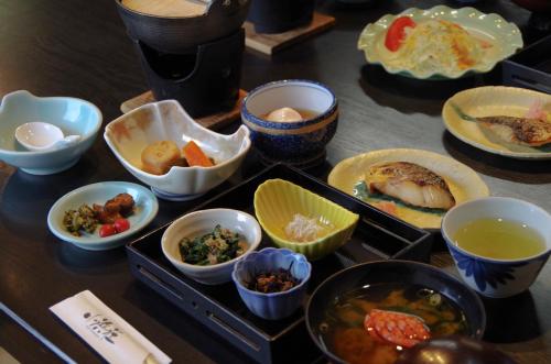 a table with various dishes of food on it at あじ彩の宿小浜荘 in Toba