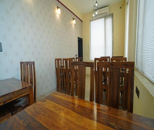 jadalnia z drewnianym stołem i krzesłami w obiekcie Ashira Inn w mieście Greater Noida