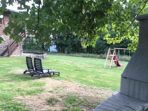 two benches sitting in a yard with a playground at Chalet de Charme in Rochehaut