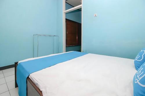 uma cama num quarto com uma parede azul em Ambon Residence Syariah em Ambon