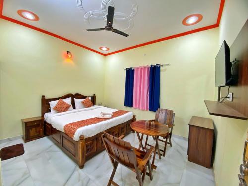 a bedroom with a bed and a table and a television at The Kukas Resort in Jaipur