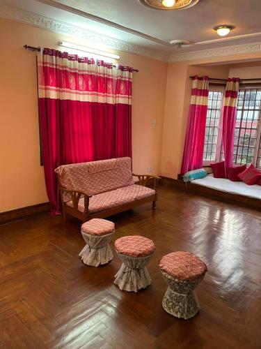 sala de estar con sofá y 2 taburetes en Fully furnished 1bhk flat near dhumbarahi area en Katmandú