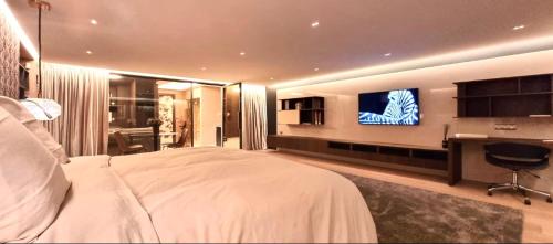 Habitación de hotel con cama grande y TV de pantalla plana. en Auprès des vignes d’Amiens, en Saint-Fuscien