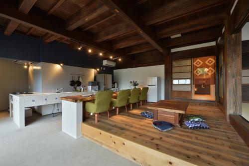 a kitchen and dining room with a table and chairs at 一棟貸し古民家の宿まるがやつ in Ōtaki