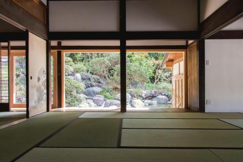 an open room with a view of a garden at 一棟貸し古民家の宿まるがやつ in Ōtaki