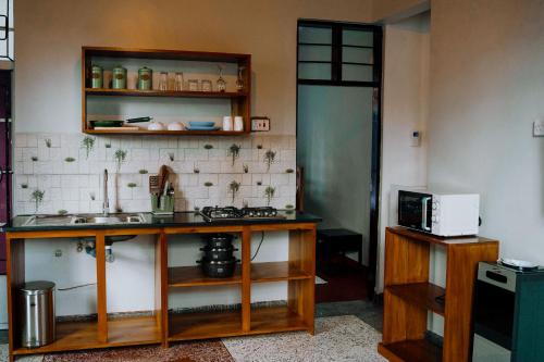 a kitchen with a counter with a sink and a microwave at Staycation by Drew in Dar es Salaam
