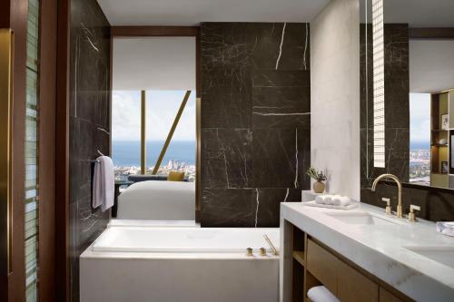 a bathroom with a bath tub and a sink at The Ritz-Carlton, Melbourne in Melbourne