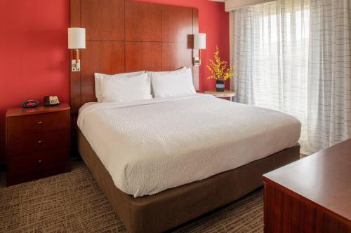 duże łóżko w pokoju hotelowym z czerwonymi ścianami w obiekcie Residence Inn by Marriott Helena w mieście Helena