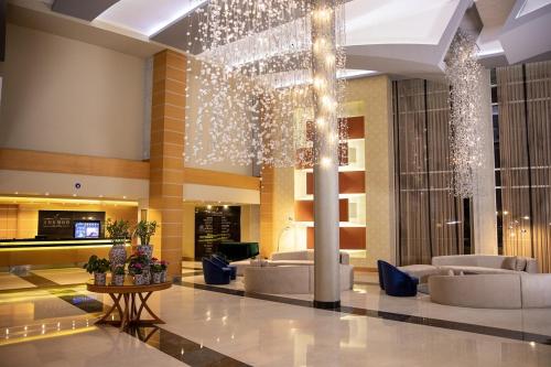 un vestíbulo con sofás y una lámpara de araña en un edificio en Anemon Grand Adana Otel, en Adana