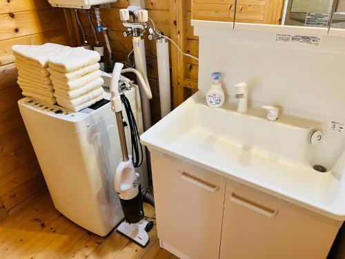 een badkamer met een wastafel, een toilet en handdoeken bij Shirakaba no mori Cottage - Vacation STAY 90794v in Abashiri