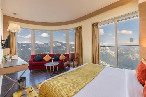 um quarto de hotel com uma cama e uma grande janela em Echor Shimla Hotel - The Zion em Shimla