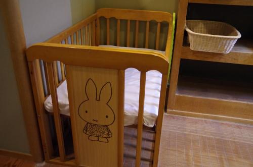 a small wooden crib with a bunny sticker on it at あじ彩の宿小浜荘 in Toba