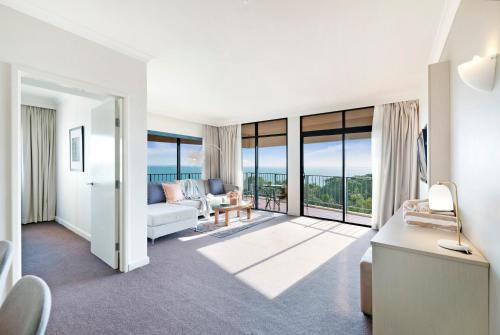 - un salon avec un canapé et une table dans l'établissement Oceanview Corner - Resort-like Living with Pool, à Darwin