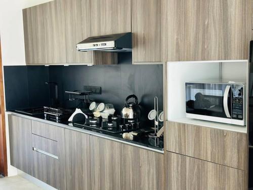 a kitchen with a microwave and a stove top oven at Lake Round Luxury House in Kurunegala