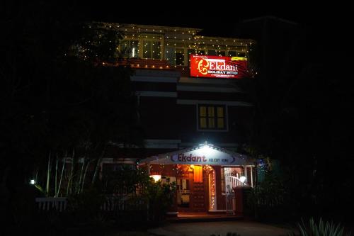a building with a lit up sign at night at Redstone House by Oxystays Hospitality in Ganpatipule