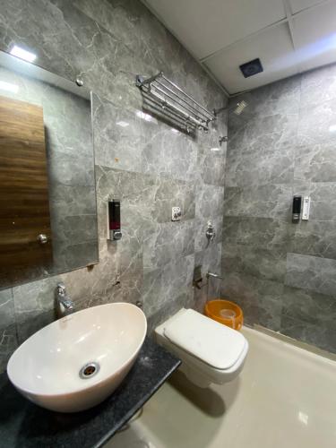 a bathroom with a sink and a toilet at Hotel Blue Wellington - Near Mumbai Airport in Mumbai