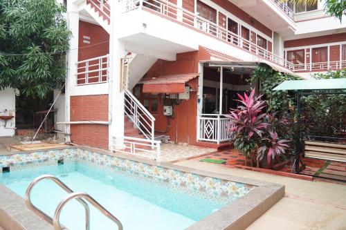 a building with a swimming pool in front of a building at Redstone House by Oxystays Hospitality in Ganpatipule