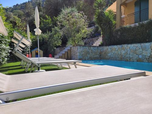 une piscine avec un banc à côté d'une maison dans l'établissement APARTMENT VILLA ABOVE MONACO, à La Turbie