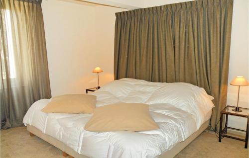 um quarto com uma cama branca e 2 almofadas em Amazing Home In St Didier With 4 Bedrooms And Wifi em Saint-Didier