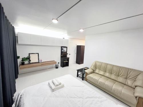 uma sala de estar com uma cama e um sofá em Impact-Don Mueang Bangkok Popular Condo C4 em Pak Kret