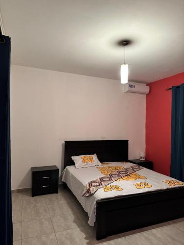 una camera con letto e parete rossa di Le bonheur a Dzaoudzi