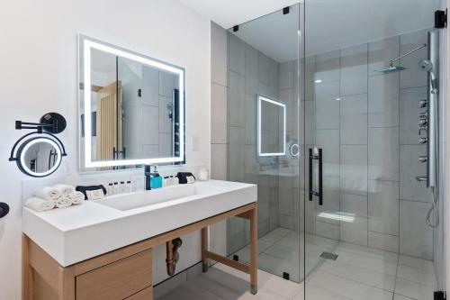 a white bathroom with a sink and a shower at Malibu Sand Carbon Beach Suites in Malibu