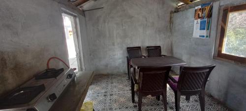 Habitación con mesa, sillas y ventana en Bhumika Home Stay, en Kapkot