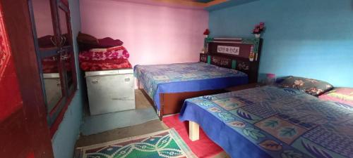 1 dormitorio con 2 camas y vestidor en Bhumika Home Stay, en Kapkot