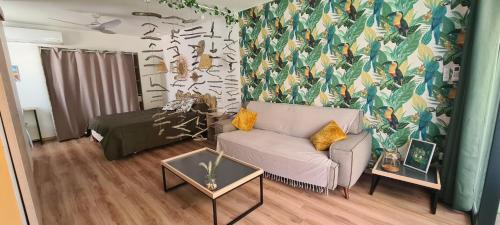 a living room with a couch and a bed at Coquet appartement à 50 m du lagon in Étang-Salé les Bains