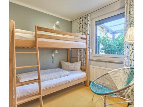 a bedroom with two bunk beds and a chair at Atelier Gaesthaus in Sietow Dorf
