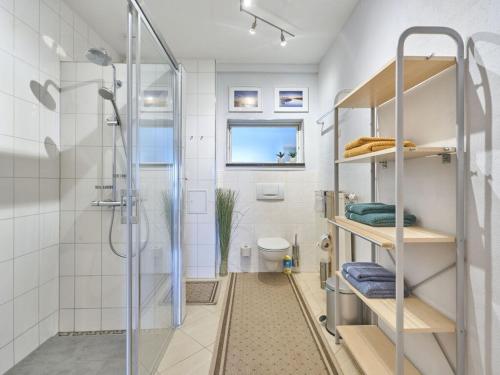 a white bathroom with a shower and a toilet at Atelier Gaesthaus in Sietow Dorf