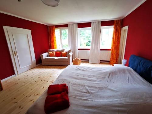 a bedroom with a white bed and red walls at Sophienhof Lieselotte in Neuenkirchen