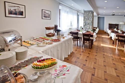 a restaurant with white tables with food on them at Urocza Art Pensjonat in Krynica Zdrój
