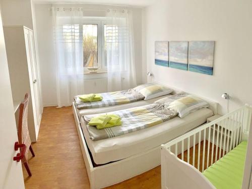 ein Schlafzimmer mit 2 Betten und einem Kinderbett in der Unterkunft Holiday apartment sea air in Langeoog